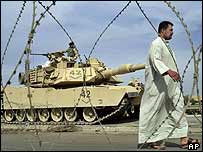 Muž míjí americký tank v Iráku