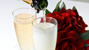Romance: champagne being poured, with roses in the background