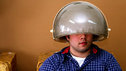 Man sitting under an old-fashioned hairdryer