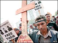 Homem segura cruz em protesto em Jacarta