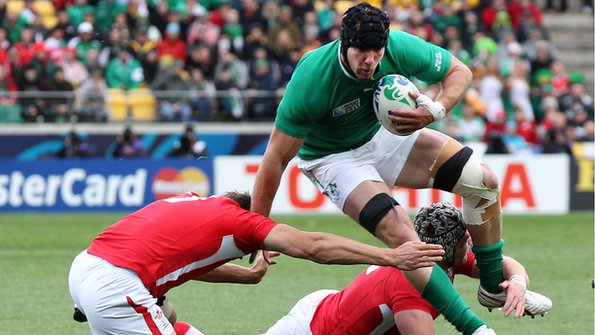 Ireland flanker Stephen Ferris is enveloped by two Welsh tacklers