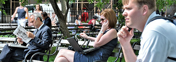 People talking and browsing the web in a park