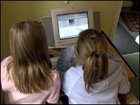 Two girls sitting at a PC