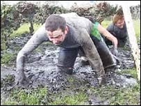 man crawling through mud