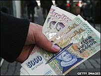 A bank customer holds a handful of Icelandic crowns in Reykjavik