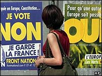 Mulher passa em frente a cartazes de campanha sobre o referendo