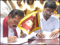 Tilvin Silva (R) signing an electoral pact with PM Rajapaksa