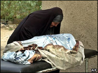 Mulher chora em cima de corpo do filho