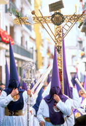 Adults and children dressed in tall, pointed, bright blue hoods at a Spanish Holy Week festival