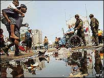 Homens carregam pessoa ferida pelo furacão Katrina