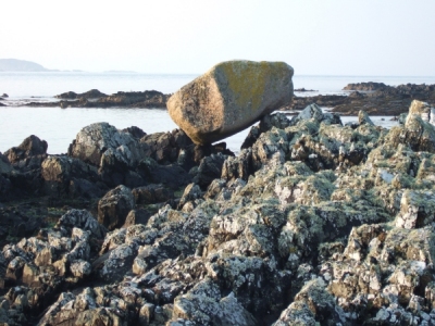 Glacial erratic boulder of Ross of Mull granite sitting on top of Torridonian rocks of Iona