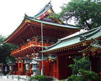 Kanda Myojin shrine gate, brightly painted with typical Japanese roofs and stone lanterns outside
