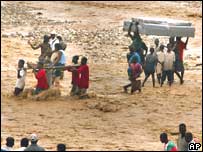 Haitianos atravessam rio após colapso de ponte durante a passagem do furacão Dennis pelo Haiti