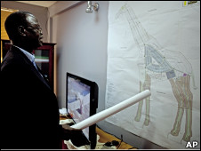 Dr. Daniel Wani, Undersecretary for the Ministry of Housing and Physical Planning in the Government of South Sudan, explains a map of Wau in the shape of an giraffe