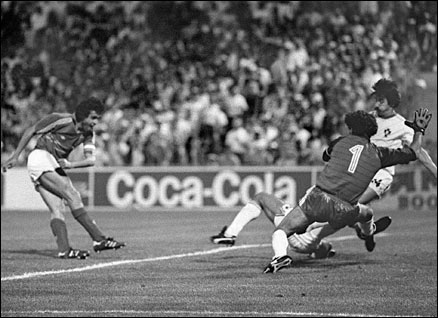 French captain and midfielder Michel Platini scores the winning goal in extra time as Portuguese goalkeeper Bento and defender Frasco dive in vain during the 1984 European Championship semi-final