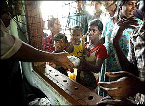 Obyvatelé Srí Lanky stojí frontu na potraviny před kostelem ve městě Hikkaduwa