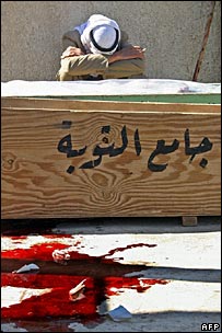  باقعوبہ میں ایک شخص اپنے رشتہ دار کے تابوت کے ساتھ بیٹھا رو رہا ہے