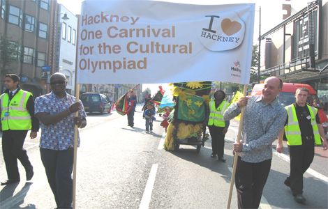 Eddie Nestor and Hackney's Mayor Jules Pipe walk with the Cultural Olympiad Carnival banner through Mare Street