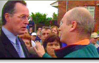 Image of Gerry Kelly and Billy Hutchinson confronting each other outside Holy Cross Primary School