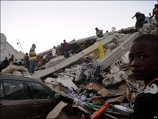 Personas caminan entre los escombros