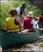 People canoeing along a river
