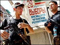 Milicianos chechenos do lado de fora de um local de votação