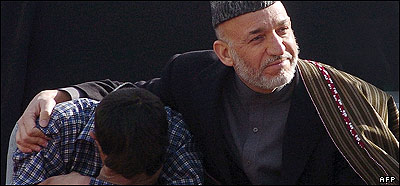 حامد کرزئی سکول کے دورے پر ایک بچے کو پیار کر رہے ہیں