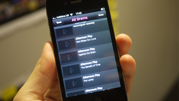 iPhone in hand, loading up an episodes list screen, showing the BBC iPlayer icon as a loading screen.