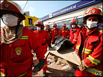 Bombeiros transportam corpo em Pisco