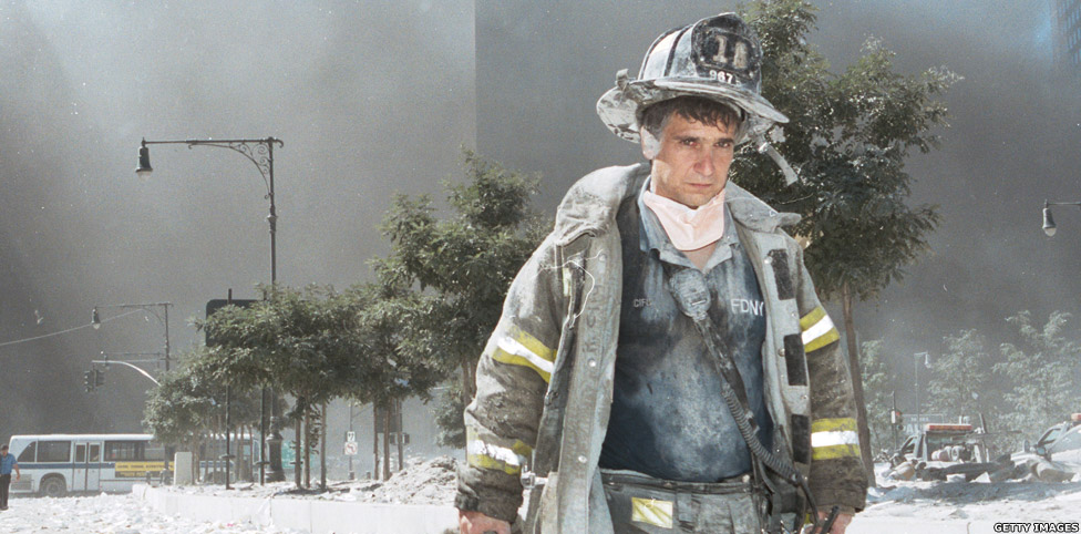 Un bombero de Nueva York se aleja de la Zona Cero, cubierto de polvo de los escombros tras el colapso de las Torres Gemelas del World Trade Center.