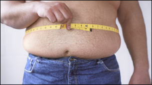 Fat man measuring his waist