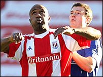 Jonny Evans của Man U tranh bóng cùng với Ricardo Fuller của Stoke City