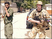 يک سرباز پليس افغان (سمت چپ)، در کنار سرباز خارجی آيساف در کابل