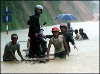 Dùng thuyền chở xe máy qua nơi ngập lụt ở Lào Cai - ảnh TTXVN