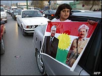 Kürt yönetimi bayrağı üzerinde Celal Talabani ve Mesut Barzani fotografları