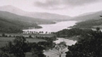 Black and white view of Loch Tummel with hills around and Schiehallion behind.